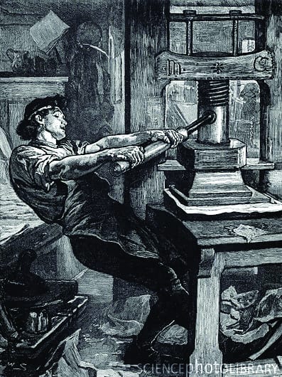 A printer laboriously works a 16th century screw press. These archaic printing presses were developed by Gutenberg based on similar designs used for the crushing of grapes to make wine