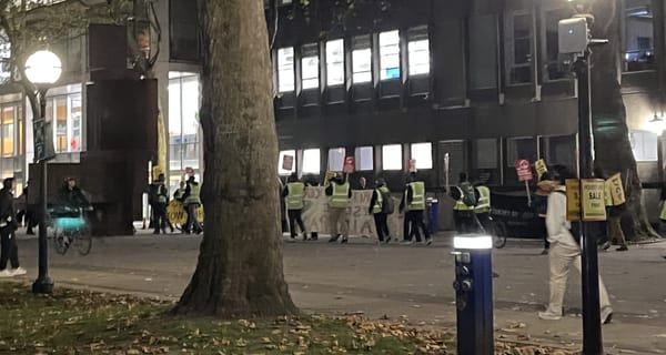 Students watch as striking museum security guards march through South Kensington